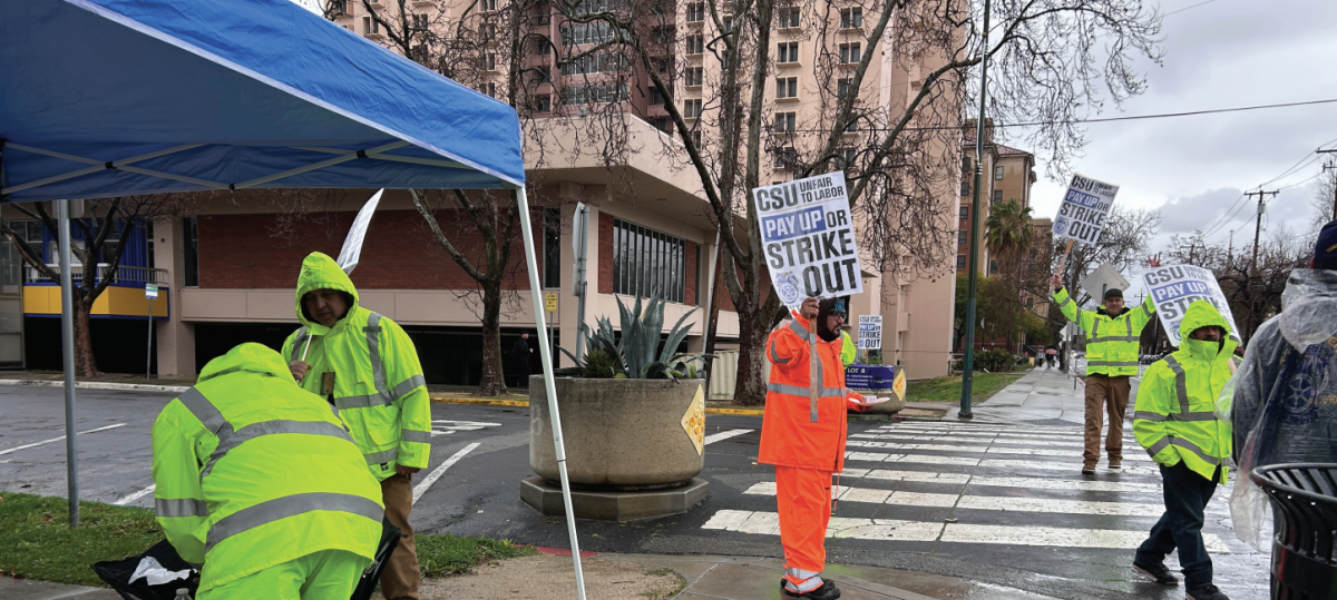 Skilled trade workers strike on East San Salvador street outside of the San José State Dining Commons on Tuesday morning during rainy weather.