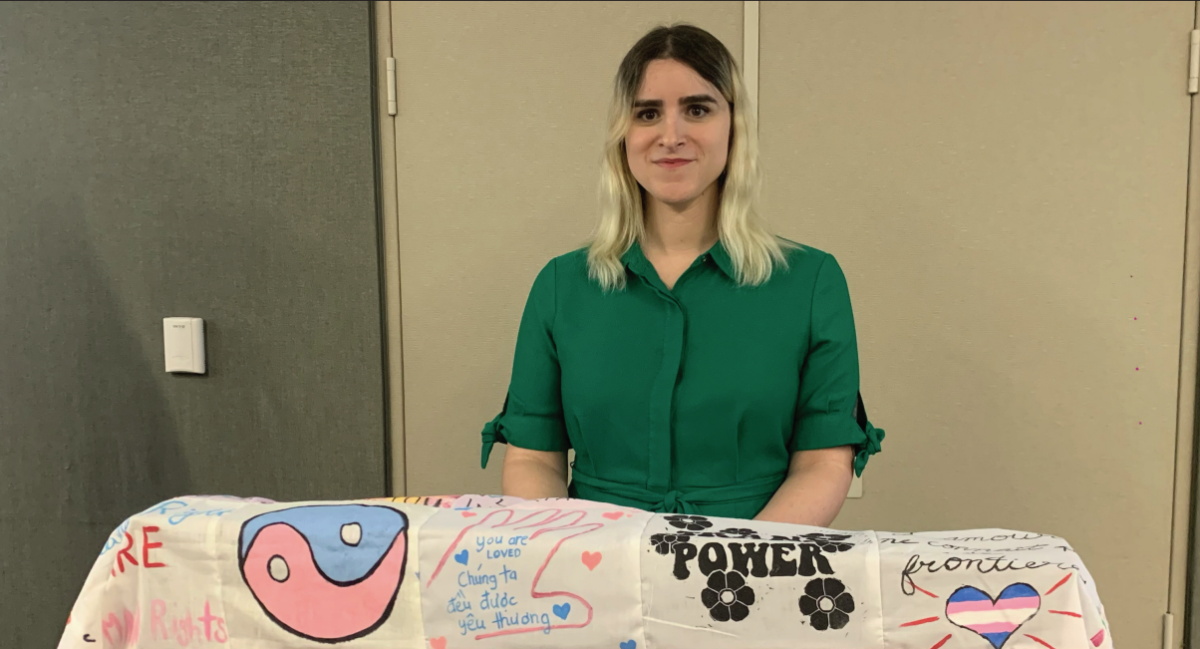 Erin Reed smiles from the podium after her speech. The trans flag was decorated by students provided by assistant professor Soma de Borboun. 