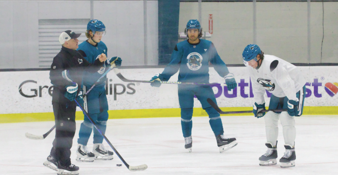 Center Will Smith (second from left), left-winger Kiefer Sherwood (middle) and left wing William Eklund (right) listen to assistant coach Doug Houda (left) on Tuesday.