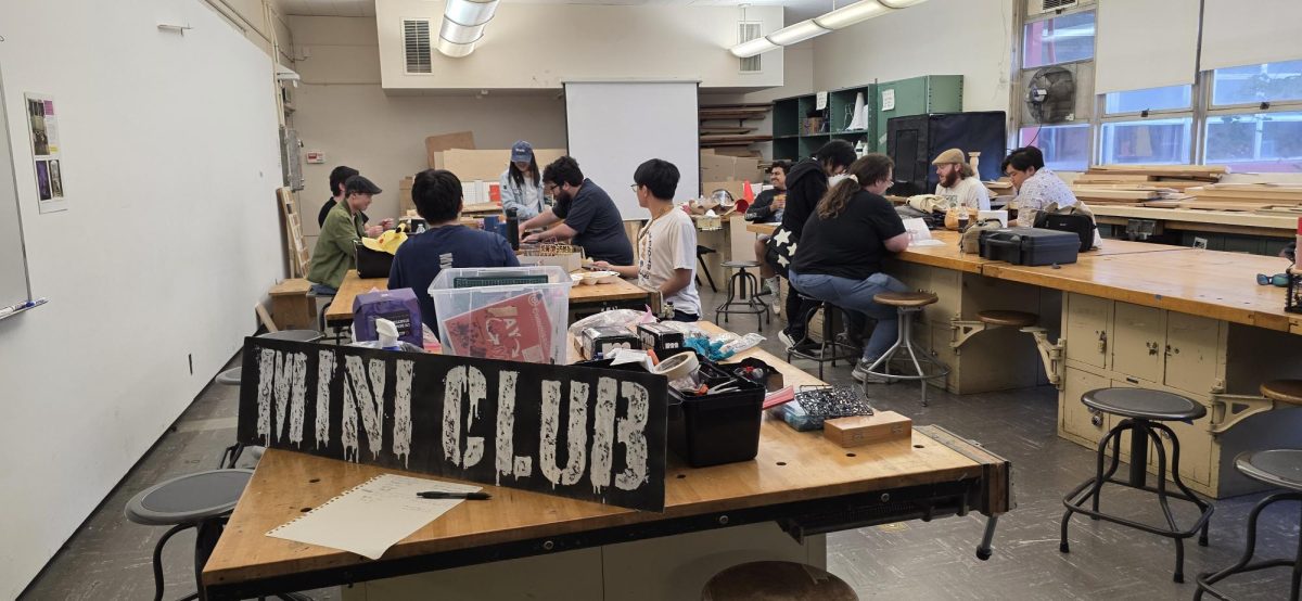 Members of the Mini Club converse with each other while painting and gaming.