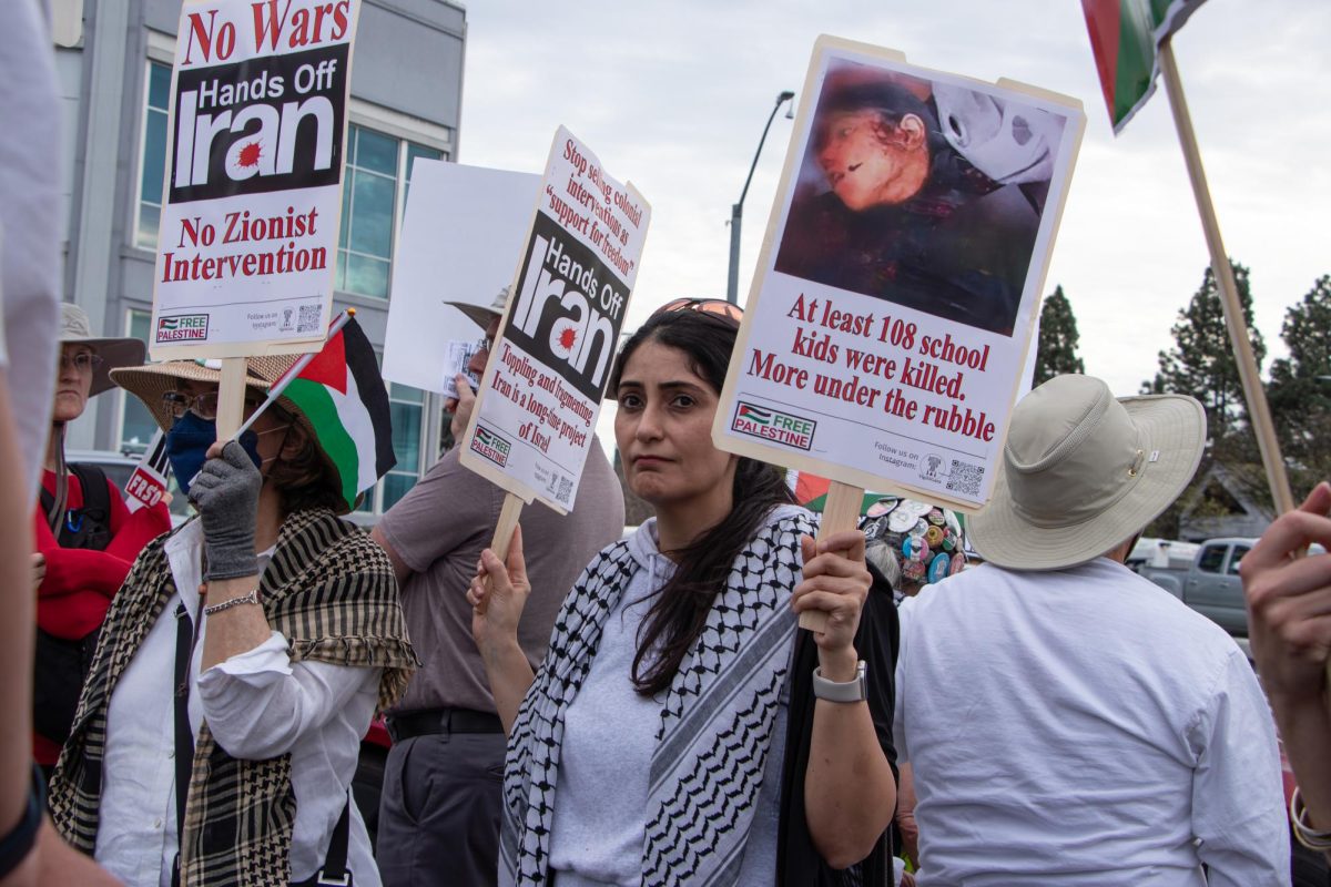 Protesters hold signs opposing US-Israeli military strikes on Iran and Palestine outside Santana Row on Saturday.