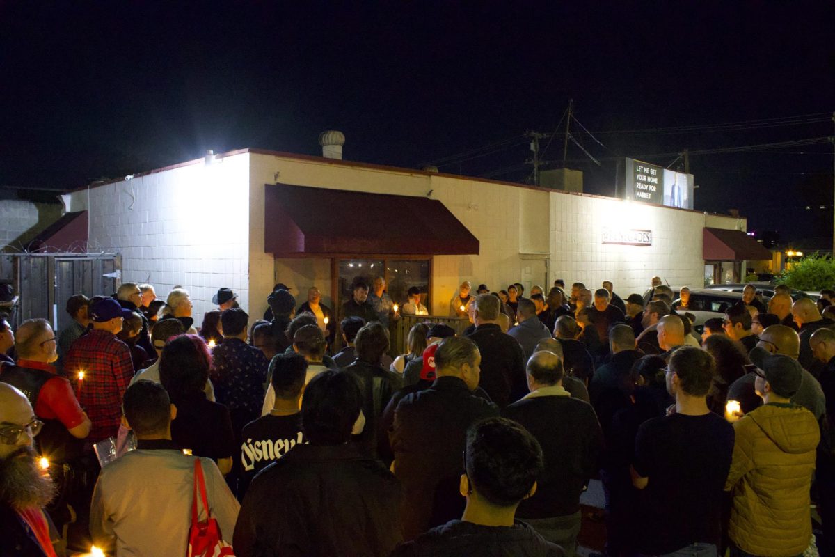 Community members gather around the side of Renegades holding candles and reminiscing the memories they had inside of the bar on March 6. Luis Sarmiento was the owner of the Renegades bar in San José.