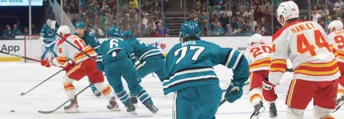 Center Michael Misa and the San José Sharks race after the puck in Calgary center Morgan Frost’s possesion. Misa scored once in each game following this matchup.