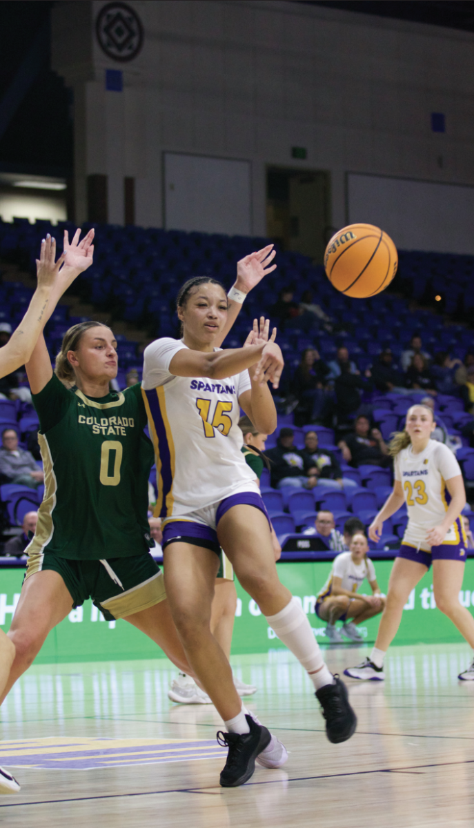 Sophomore guard/foward Maya Anderson (15) passes while getting boxed out of the key by Colorado State University senior forward Madelyn Bragg (0) on Tuesday.