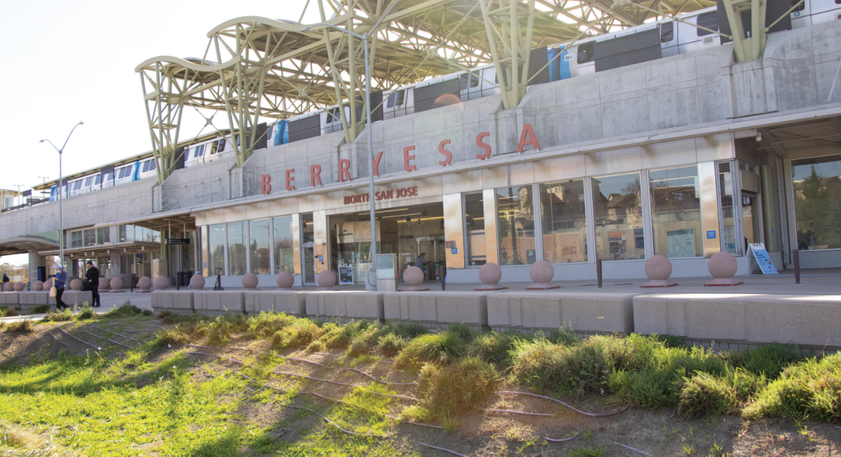 Commuters stand outside of the Berryessa / North San José BART Station while a person is tapping in to enter through the fare gates on Tuesday afternoon.