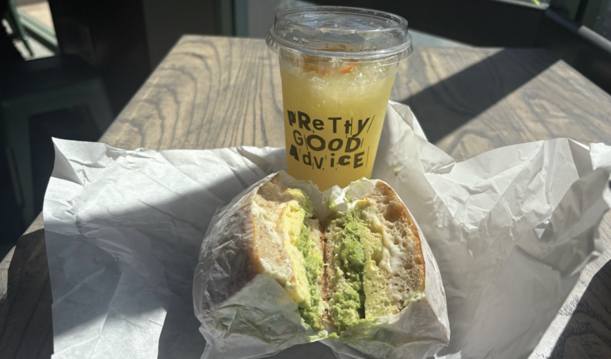 Mike’s Deluxe cut in a cross section filled with egg, avocado, pepper jack cheese and tarragon aioli in between sourdough foccacia bread alongside Mandarin Lemonade.
