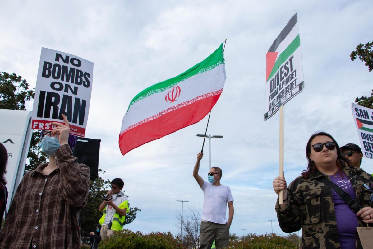 Protesters hold Iranian flags and signs opposing U.S.-Israeli strikes on Iran at Santana Row on Feb. 28.