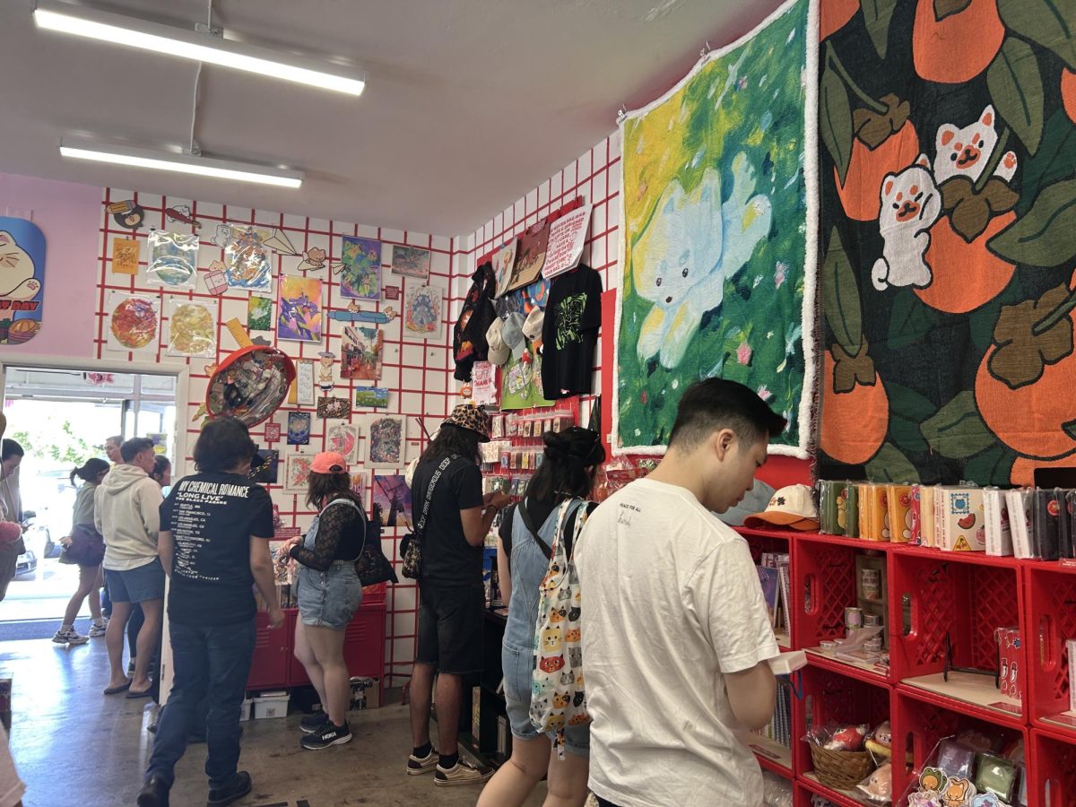 Customers inside of MOMENT Japantown on Jackson Street shop and view the featured cat-themed art show during San José Cat Day.