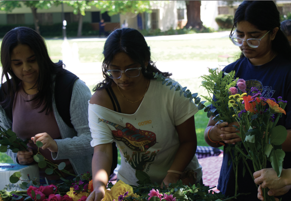 Naina Talasu, Eesha Maddali and Bardhini Battangi make bouquets at the Bouquets & Beignets event on Friday.