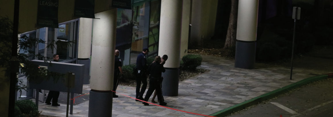 San José Police Department officers escort a subject from the Colonnade Apartments across the street from campus on Monday.