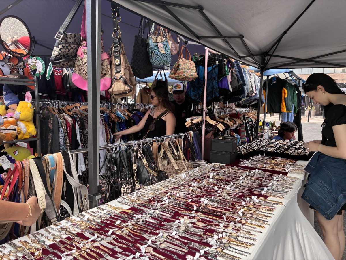 Attendees take their time browsing Y2K Coach bags and vintage accessories in the vintage vendor section at the Santa Clara Night Market.