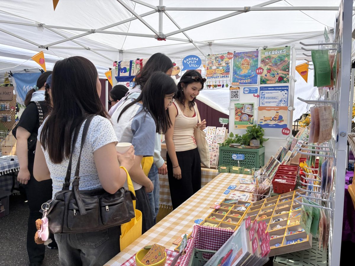 SJMade Fest attendees observe the different original crafts available at a small business booth.